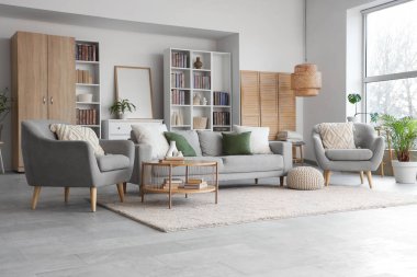 Kitaplıkları, kanepesi, koltuğu ve sehpası olan modern oturma odasının içinde.