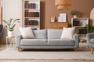 Kitaplıkları ve rahat kanepesi olan modern oturma odasının içinde.