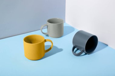 Mavi arkaplanda farklı seramik bardaklar