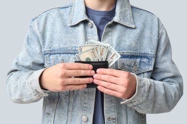 Cüzdanında dolar banknotları olan genç bir adam, yakın plan.