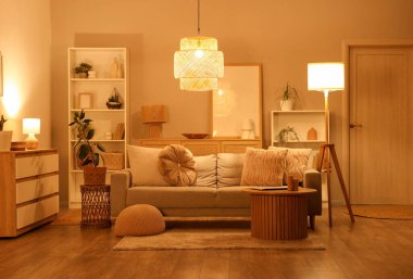 Rahat bir kanepe, oturma odasının içinde dizüstü bilgisayarı olan bir sehpa.