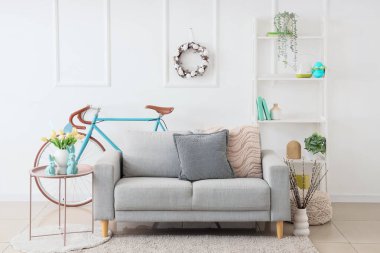 Koltuğu, bisikleti ve Paskalya çelengi olan aydınlık oturma odasının içinde.