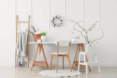 Çalışma yeri, merdiven ve Paskalya çelengi olan hafif bir ofis.