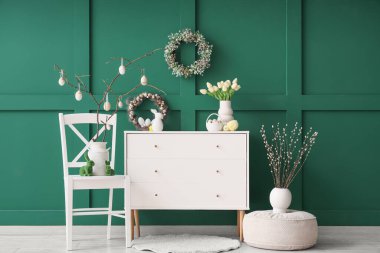 Klozet, sandalye ve Paskalya çelenkleri olan bir oda.