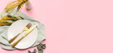 Pembe zemin üzerinde mimoza çiçekleri ve metin için yeri olan güzel masa ayarları