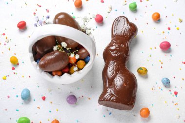 Beyaz arka planda sepet ve yumurtalı Paskalya tavşanı.