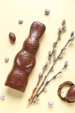 Yumurtalı ve sarı arka planda söğüt dallı Paskalya tavşanı.