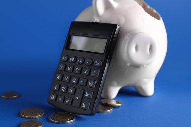 Bozuk para ve hesap makinesi olan kırık bir kumbara.