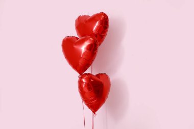 Pembe arka planda kalp şeklinde hava balonları. Sevgililer Günü kutlaması