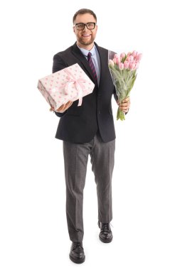 Beyaz arka planda laleleri ve hediye kutusu olan yakışıklı bir iş adamı. Uluslararası Kadınlar Günü kutlamaları