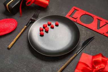 Sevgililer Günü için güzel bir masa. Siyah grunge arka planında sevgi, hediyeler ve kalplerle dolu.