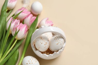 Paskalya yumurtaları ve bej arkaplanda laleler.