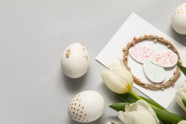 Paskalya yumurtalı laleler ve beyaz arka planda neşeli kartpostallar.