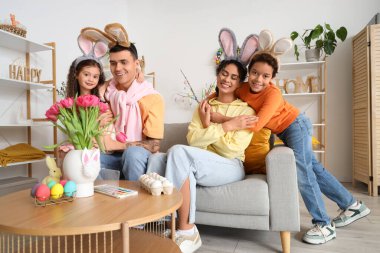 Paskalya günü evde tavşan kulaklı mutlu bir aile.