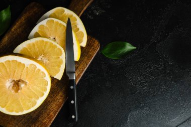 Siyah arka planda taze nar meyvesi kesilmiş ahşap tahta.