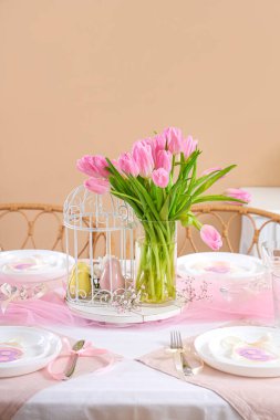 Uluslararası Kadınlar Günü için lale çiçekleriyle güzel bir masa. Renk duvarının yanında.