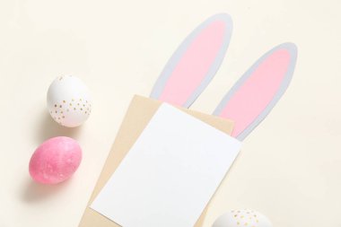 Bej arka planda Paskalya yumurtaları ve boş kartlı yaratıcı kompozisyon