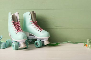 Beyaz ahşap masada eski patenler ve oyuncak tavşanlar. Paskalya kutlaması