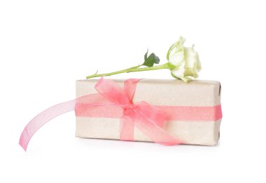 Pembe fiyonklu hediye kutusu ve beyaz arka planda güzel bir gül. Uluslararası Kadınlar Günü