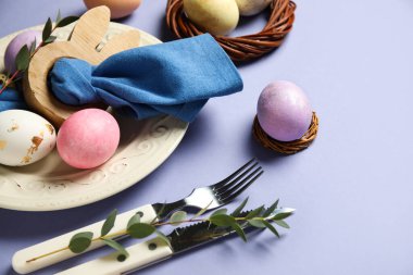 Eflatun arkaplanda Paskalya yumurtaları olan güzel bir masa.