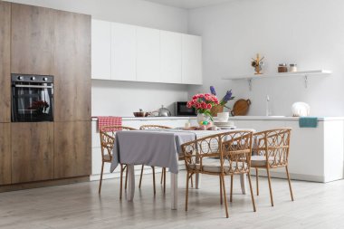 Paskalya yumurtaları, laleler ve yemek takımlarıyla dolu yemek masası.