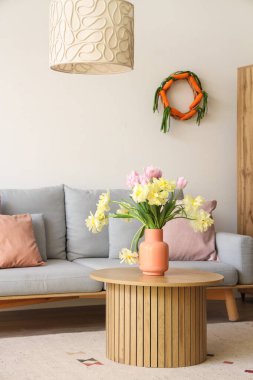 Paskalya kutlaması için dekore edilmiş modern oturma odası. Masada güzel laleler var.