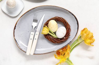 Paskalya yumurtaları ve beyaz arka planda güzel laleler.