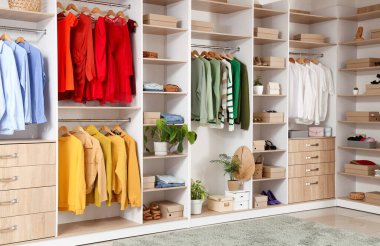 Soyunma odasında farklı kıyafetleri ve aksesuarları olan büyük gardırop.