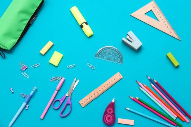 Mavi arka planda farklı bir kırtasiye malzemesi. Üst görünüm