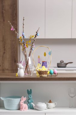 Mutfaktaki masada söğüt dalları ve paskalya yumurtaları olan vazo.