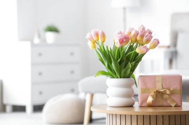 Yatak odasındaki Uluslararası Kadınlar Günü için laleli vazo ve hediye kutusu.