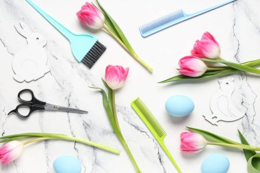 Kuaför aletleri, lale çiçekleri ve arka planda Paskalya yumurtaları olan kompozisyon