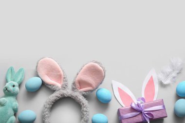 Paskalya yumurtası ve beyaz arka planda hediye kutusu olan tavşan kulakları.