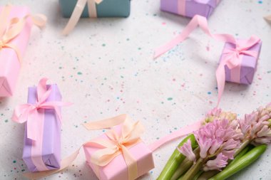 Hediye kutularından yapılmış çerçeve ve beyaz benekli masada sümbül çiçeği.