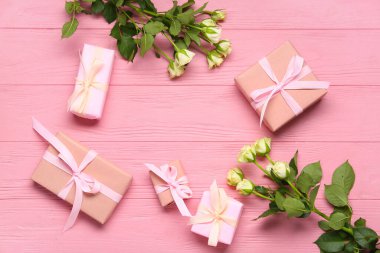 Hediye kutularından yapılmış çerçeve ve pembe ahşap arka planda beyaz güller. Üst görünüm