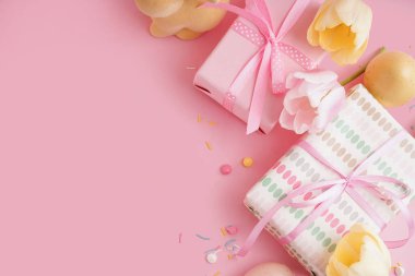 Paskalya hediyesi kutuları pembe arka planda lale çiçekleri