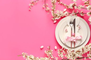 Pembe arka planda çiçek açan dalları olan güzel Paskalya masası.