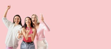 Mutlu genç kadınlar pembe arka planda şampanya içerken mesaj atmak için yer açıyorlar. Kız Partisi