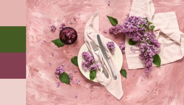 Pembe arkaplanda leylak çiçekleri olan güzel bir masa. Farklı renk desenleri