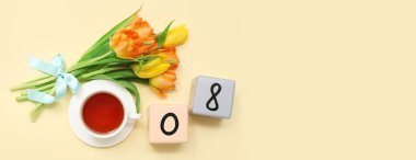 Takvim, güzel laleler ve bej arka planda bir fincan çay. Mesaj için yer var. Uluslararası Kadınlar Günü