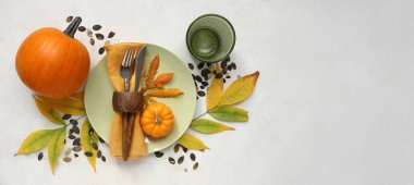 Taze balkabaklarıyla ve arka planda sonbahar yapraklarıyla güzel bir masa, üst manzara.