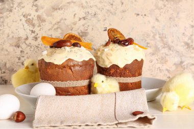 Tavuklu Paskalya pastası ve bej rengi grunge duvarın yanındaki beyaz ahşap masada yumurtalar.