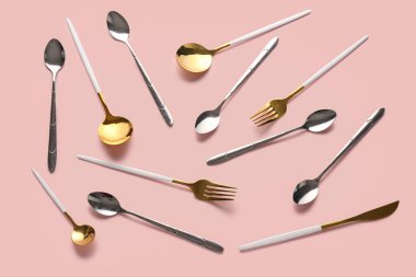 Pembe arka planda farklı paslanmaz çelik çatal bıçak seti