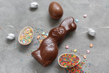 Çikolatalı Paskalya yumurtaları, gri arka planda serpiştirilmiş tavşanlar