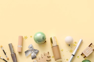 Dekoratif kozmetik ürünleri ve bej arka planda Noel dekoru olan kompozisyon