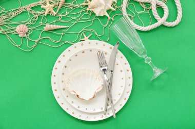 Yeşil arka planda deniz dekoruyla servis edilen güzel bir masa.