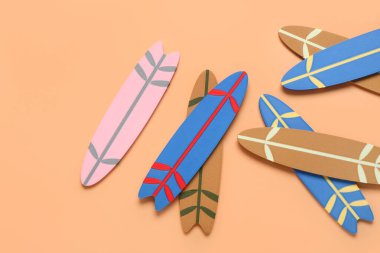 Turuncu arka planda farklı mini sörf tahtaları