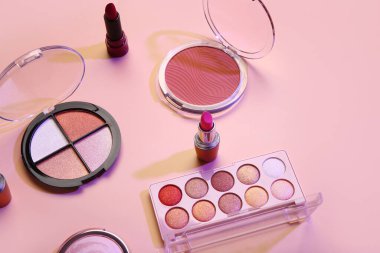 Güzel göz falı paletleri ve pembe arka planda farklı dekoratif kozmetikler.