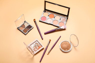 Turuncu arka planda farklı dekoratif kozmetik ürünler