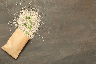 Granüler gübre ve gri grunge arka planda fideler içeren kağıt torba.